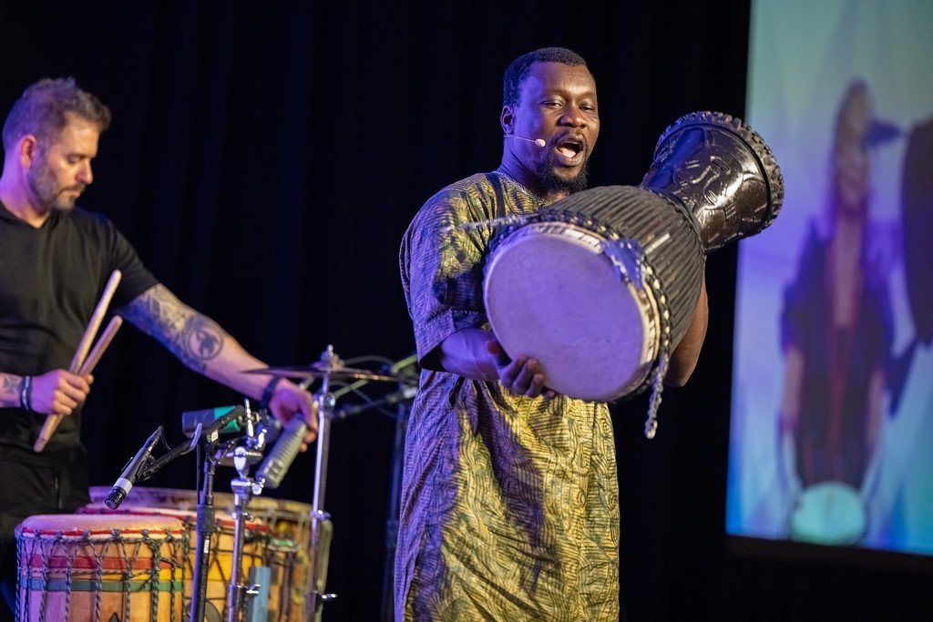 Drum Cafe session leader holding a djembe drum